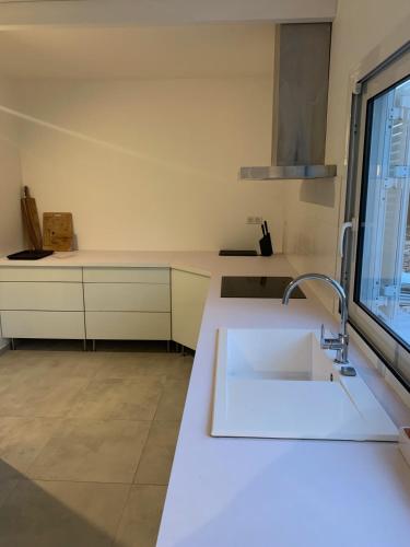 une cuisine blanche avec un évier et une fenêtre dans l'établissement Casa Canetto, vous y êtes déjà! 14 personnes, à Bonifacio