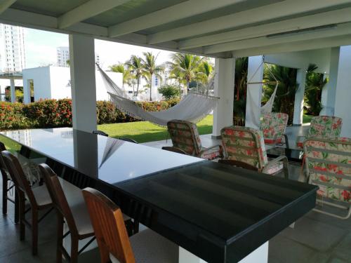 einen schwarzen Tisch und Stühle auf einer Veranda mit einer Hängematte in der Unterkunft Lulu Village - Beach - Pool - Pet Friendly in Coclé