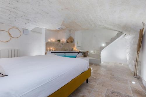 a bedroom with a white bed and a bathroom at La loge de Sarah in Montpellier