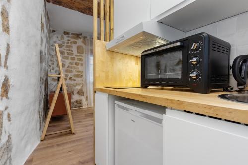 un micro-ondes posé sur un comptoir dans une cuisine dans l'établissement La loge de Sarah, à Montpellier