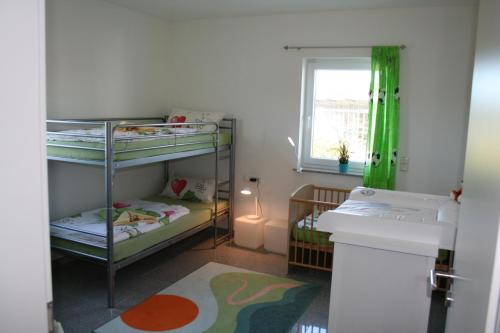 a small room with two bunk beds and a window at Ferienwohnung Hochwald 1 in Losheim