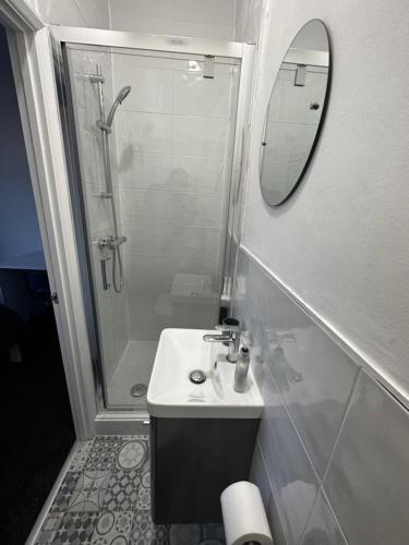 a bathroom with a sink and a shower with a mirror at Stylish Town House - Modern double room - 5 in Parkside
