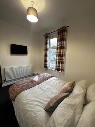ein Schlafzimmer mit einem großen weißen Bett und einem Fenster in der Unterkunft Stylish Town House - Modern double room - 5 in Parkside