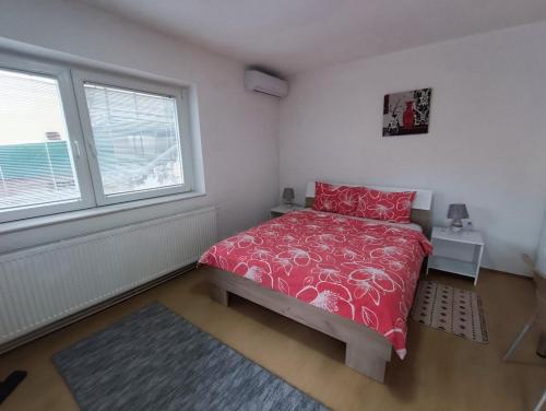sypialnia z czerwonym łóżkiem i oknem w obiekcie City Center Apartments w mieście Prilep