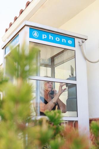 a woman talking on a phone in a phone booth at Retro Inn at Mesa Verde in Cortez