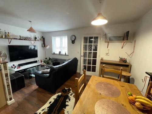 a living room with a dining room table and a television at Private room in BS14 in Bristol