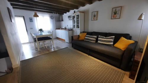 a living room with a black couch and a table at La Encina del Abuelo in La Adrada