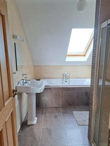 a bathroom with a sink and a bath tub at Glenmore House - ROOM ONLY in Doolin