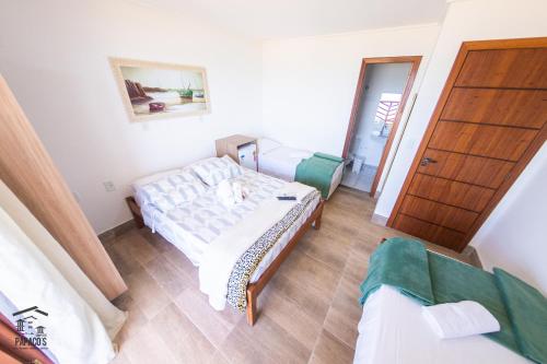 a bedroom with a bed and two green chairs at Complexo Papaco's in Anchieta