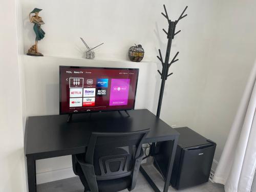 a computer desk with a monitor and a computer screen at Harmony Home Near University of Waterloo in Waterloo