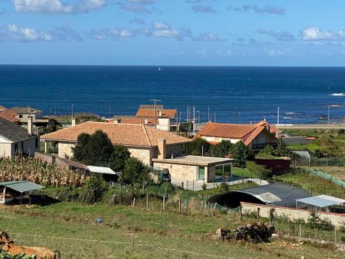a group of houses with the ocean in the background at A de Bego in Mougás