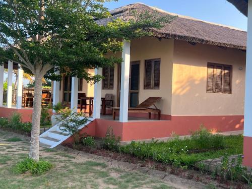 a house with a tree in front of it at Villa Moringa lodge in Lumbo