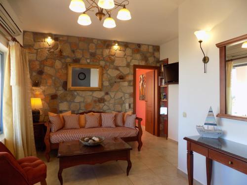 uma sala de estar com um sofá e uma parede de pedra em Alkionides Villas em Xerokampos