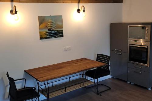 uma cozinha com uma mesa de madeira e 2 cadeiras em 50m² entièrement neuf 