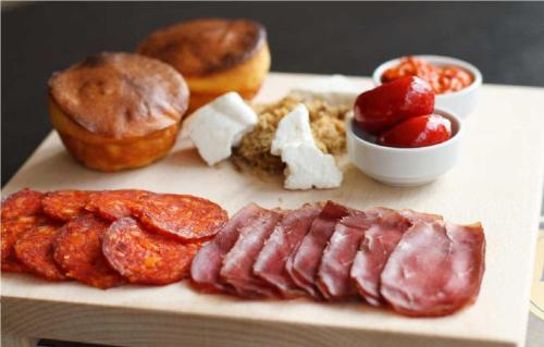 Nela apartmani (u hotelu Djina) في كوباونيك: طبق من الطعام يحتوي على نقانق ودونات وأطعمة أخرى