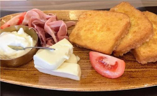 Nela apartmani (u hotelu Djina) في كوباونيك: طبق طعام يحتوي على شطيرة وخبز وزبدة