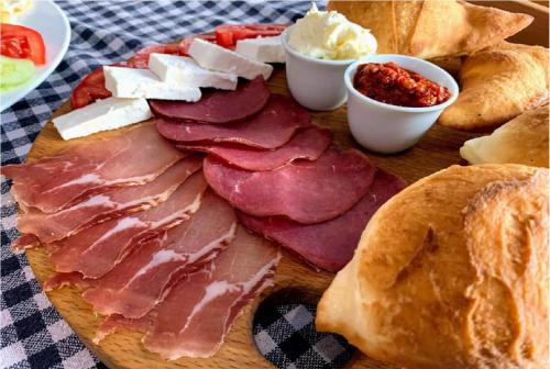 Nela apartmani (u hotelu Djina) في كوباونيك: طبق من الطعام يحتوي على اللحوم والخبز والصلصات