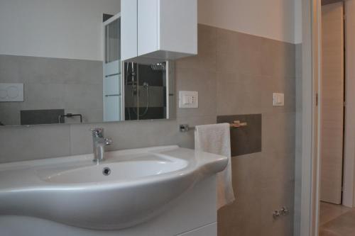 y baño con lavabo blanco y espejo. en Apartment Terre Roveresche, en San Giorgio di Pesaro