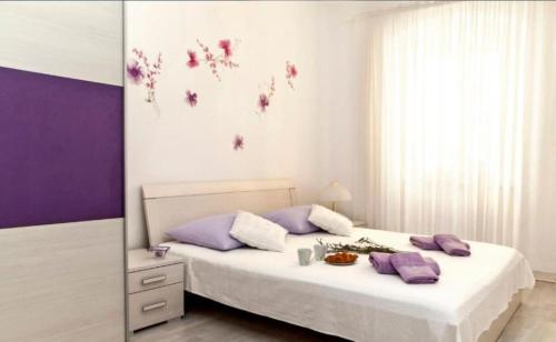 a bedroom with a bed with purple walls and purple pillows at Apartman Gaby in Center of Split in Split