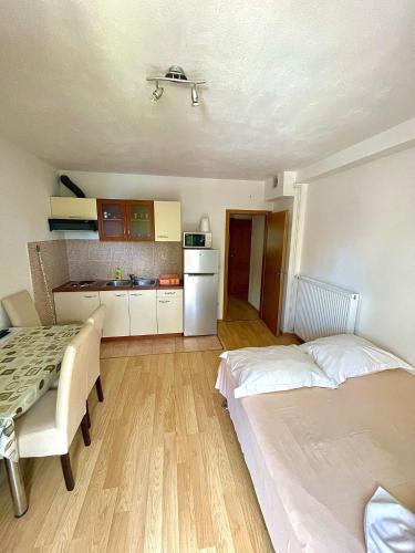a room with two beds and a table and a kitchen at Apartments Anita and Zoran in Stanići