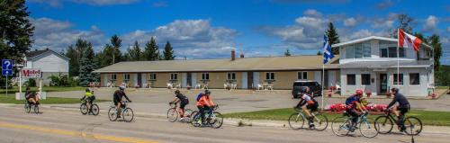 a group of people riding bikes down a street at Motel Moreau in Saint-Félicien