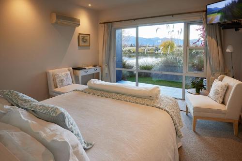 a bedroom with two beds and a large window at Matuka Lodge in Twizel