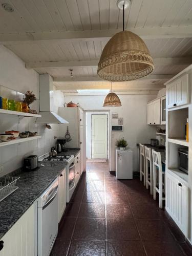 a kitchen with white cabinets and a large ceiling at Casa divina temporaria en Tafí Del Valle ,pleno centro in Tafí del Valle