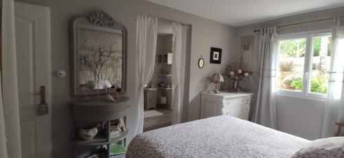 um quarto com uma cama, uma cómoda e um espelho em LE BOUILLARY em Cussac