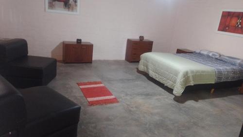 1 dormitorio con 1 cama, 1 silla y 1 sofá en CASA VISTALBA en Luján de Cuyo