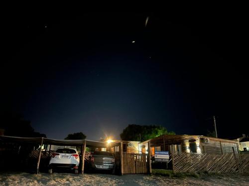 un coche aparcado delante de una casa por la noche en Tus cabañas en Las Grutas