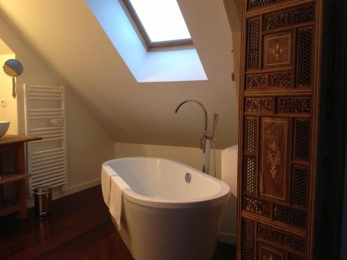 a bath tub in a bathroom with a skylight at B&B Loft Trotters in LʼÉtang-la-Ville