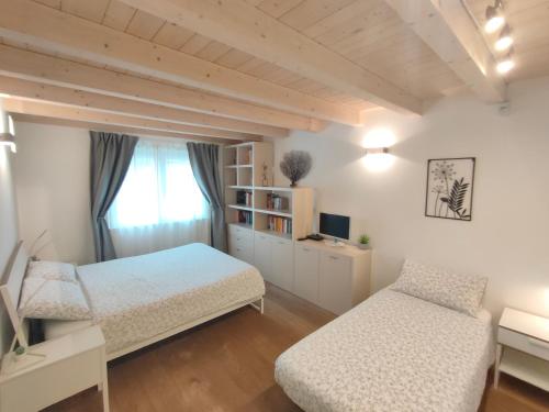 sypialnia z 2 łóżkami i oknem w obiekcie Casa Vacanze Barcola w Trieście