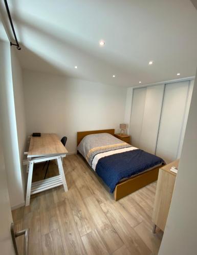 une chambre avec un lit et une table en bois dans l'établissement Le Coeur du Port de Golfe Juan - Parking - Clim - Wifi, à Vallauris