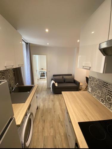 une cuisine et un salon avec un canapé dans l'établissement Le Coeur du Port de Golfe Juan - Parking - Clim - Wifi, à Vallauris