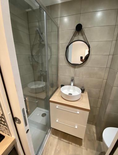 une salle de bain avec une douche, un lavabo et un miroir dans l'établissement Le Coeur du Port de Golfe Juan - Parking - Clim - Wifi, à Vallauris