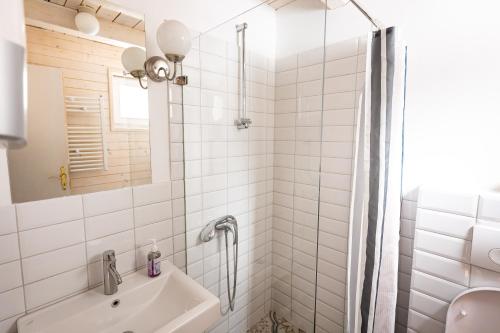 a white bathroom with a shower and a sink at ZlatAir Eco Chalet in Nova Varoš
