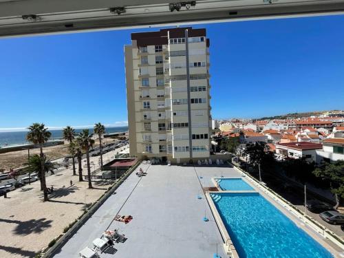 a view of a hotel with a swimming pool and a building at The View II Costa Caparica ( private parking ) in Costa da Caparica