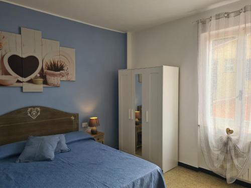 a blue bedroom with a bed and a window at Pippo a Vernazza Rooms in Vernazza