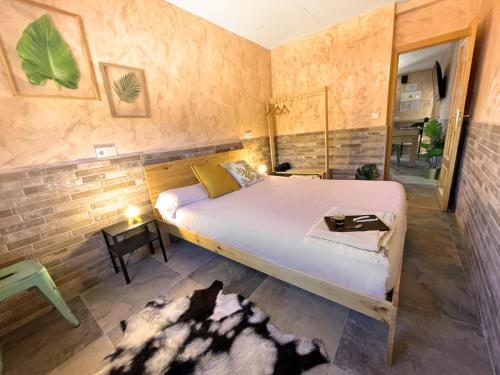 托萊多的住宿－La Mayor del Viso，一间卧室设有一张床和砖墙