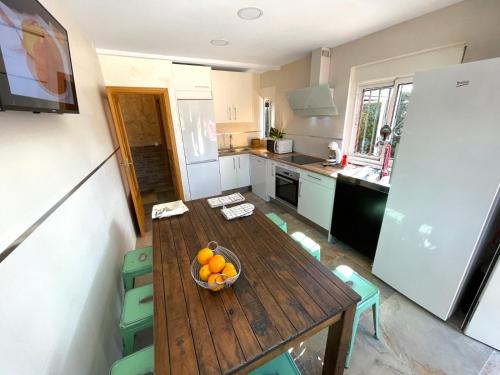a kitchen with a wooden table with a bowl of oranges at La Mayor del Viso in Toledo