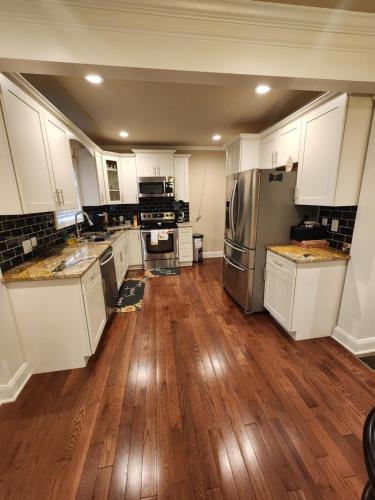 a kitchen with white cabinets and a hard wood floor at Spacious Newly Renovated Home in Atlanta