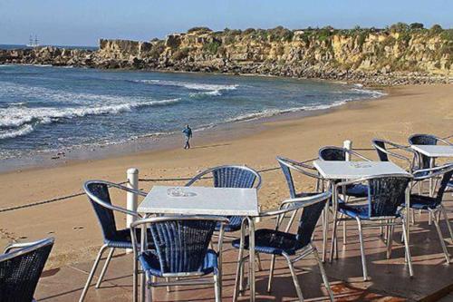 エストリルにあるEstoril Top Beach Apartmentの浜辺の一列のテーブルと椅子