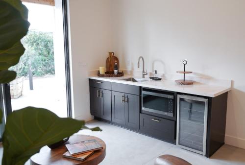 a kitchen with a sink and a microwave at Hidden Hacienda in Temecula