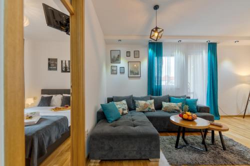 una sala de estar con un sofá y una cama en Apartman LVS Zlatibor, en Zlatibor