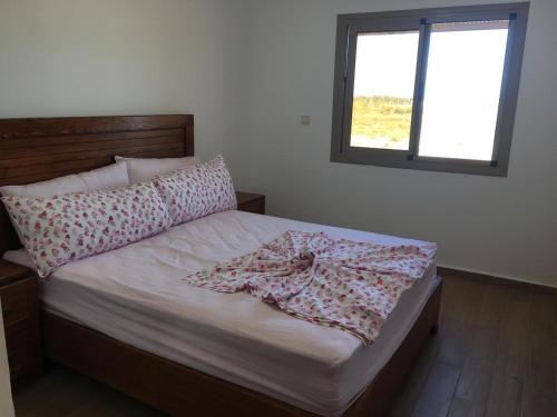 a bedroom with a bed with a pillow and a window at Apartement haut standing avec piscine à la Marina Saidia in Saidia 
