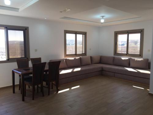 - un salon avec un canapé, une table et des chaises dans l'établissement Apartement haut standing avec piscine à la Marina Saidia, à Saïdia