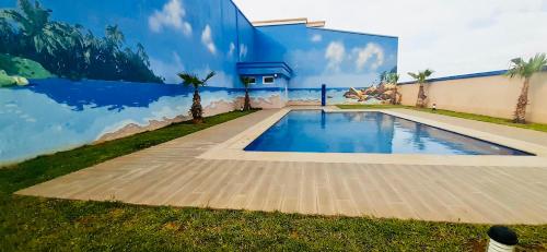 a mural on the side of a building with a swimming pool at Apartement haut standing avec piscine à la Marina Saidia in Saidia 