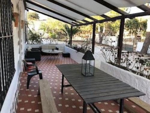 un patio con una mesa de madera y un banco en Casa Rural La Casa de Lolo, en Minas del Castillo de las Guardas