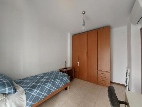 een slaapkamer met een bed en een houten kast bij Stanza Singola - Certosa in Milaan