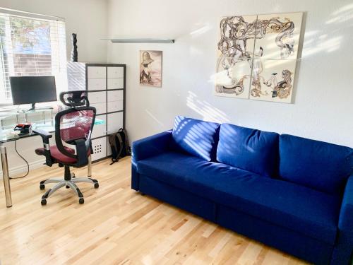 a blue couch in a room with a desk and a computer at Artsy smart home near Downtown & Balboa Park in San Diego